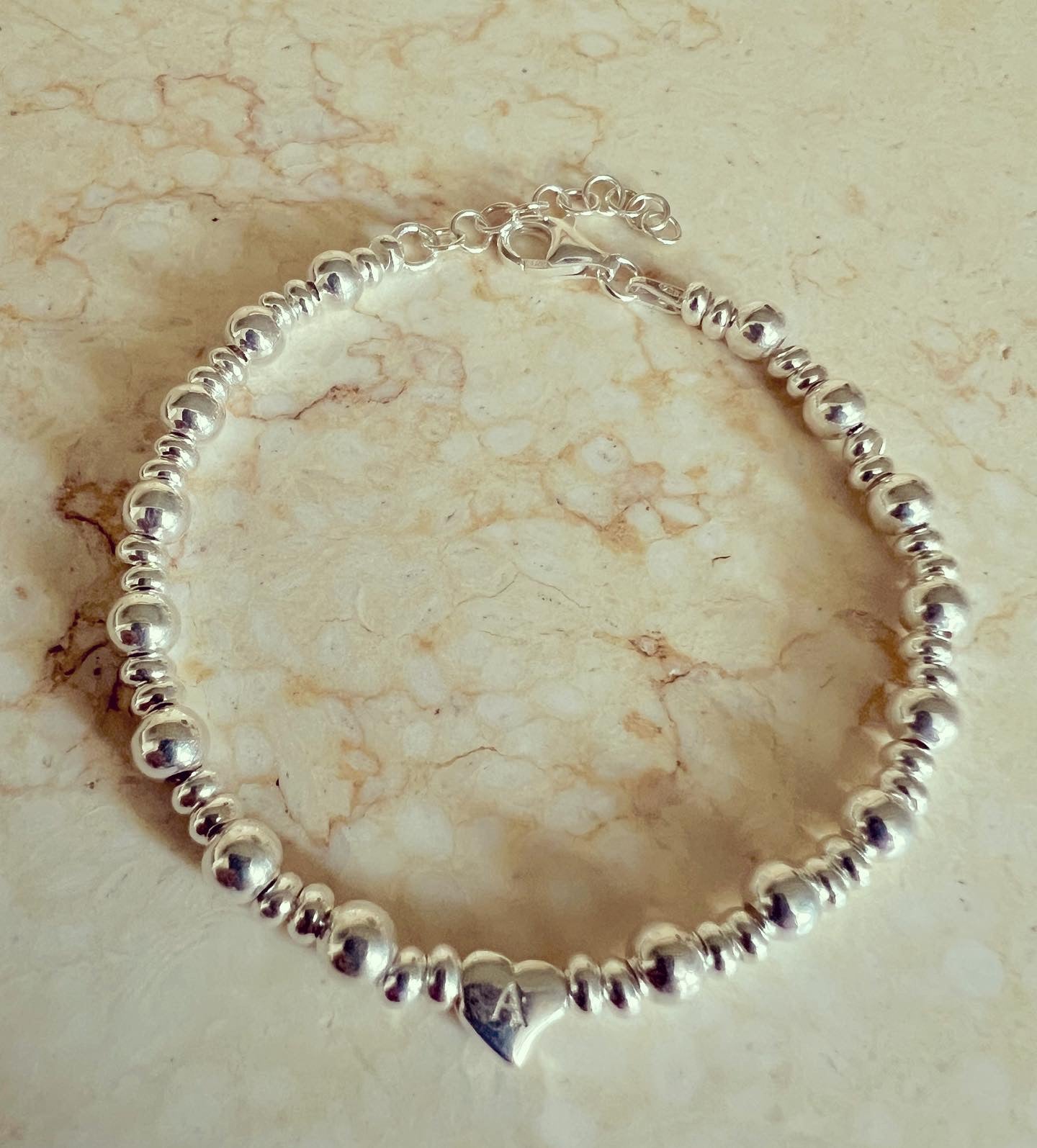 Bracciale in argento con rondelle sfere e centrale cuore iniziale